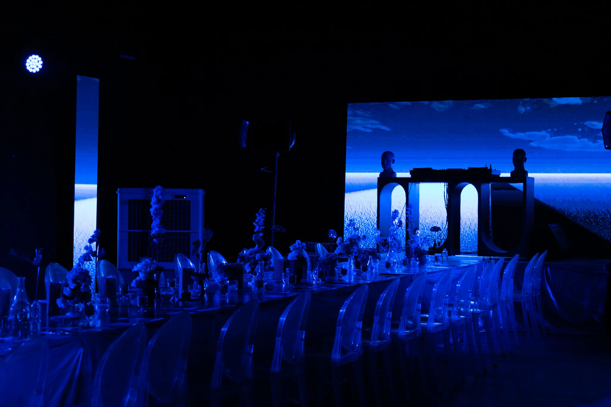 Mesa de Portal 101 iluminada en azul, con los arcos de Chakra Studio al fondo